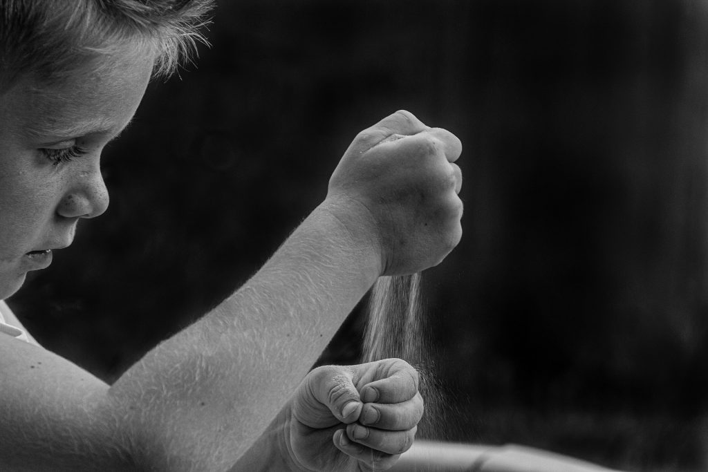 Dreng der hælder sand i hans hånd, en udredning kommer hele vejen rundt om et menneske