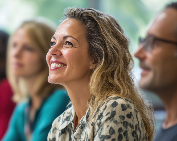 Kvinde der smiler i en forsamling.